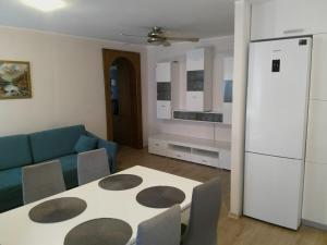 a living room with a table and a blue couch at Apartament Blisko Plaży in Gdańsk