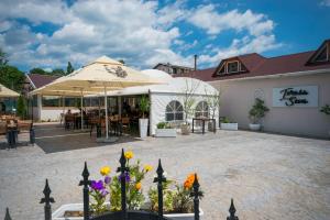 a patio at a restaurant with an umbrella and flowers at Seva Hotel Health Club in Campina
