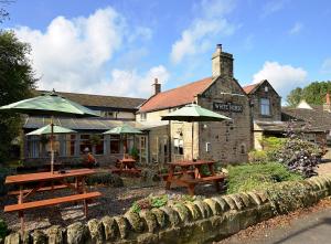 The View at the White Horse Woolley Moor في Clay Cross: طاولتين للتنزه ومظلات أمام المبنى