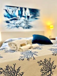 a bed with a white bedspread and pillows at Hotel Cala Di Seta in Calasetta