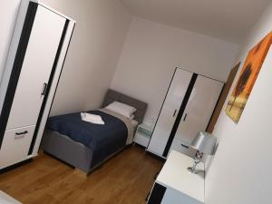 ein kleines Schlafzimmer mit einem Bett und einem Spiegel in der Unterkunft Villa MISTRAL przy plaży in Sława