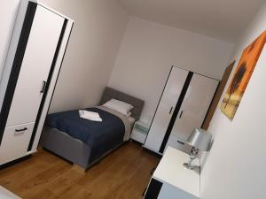 a small bedroom with a bed and a mirror at Villa MISTRAL przy plaży in Sława