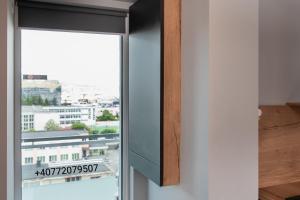 a window with a view of a city at Eriss Studio Suite - OZone building apartment in Cluj-Napoca