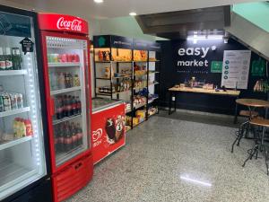 Lindo Flat na Barra da Tijuca com vista para o mar في ريو دي جانيرو: ثلاجة كوكا كولا في متجر به منضدة