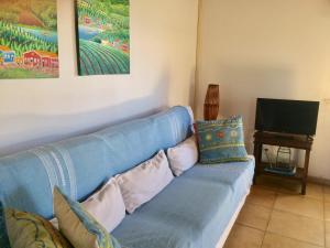a blue couch in a living room with a television at Pé na Areia in Conde