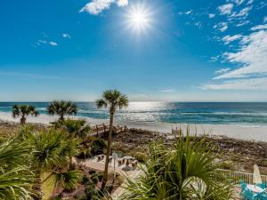 a beach with palm trees and the ocean at Sandy Key #323 in Perdido Key