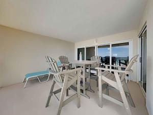 a dining room with a table and chairs and a balcony at Sandy Key #323 in Perdido Key