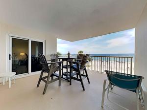 a dining room with a table and chairs on a balcony at Sandy Key #323 in Perdido Key
