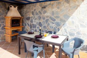 a table and chairs and a stone wall with a fireplace at Villas Rubicon I in Playa Blanca