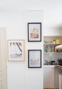 four framed pictures on a wall in a kitchen at Warm Studio en duplex proche Paris et Disney in Neuilly-Plaisance