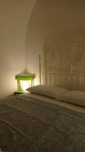 een slaapkamer met een bed en een groene tafel bij LA CASA DI BEL in Monopoli
