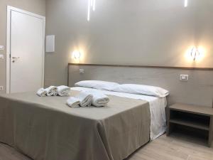 1 dormitorio con 1 cama con toallas en B&B La Perla, en Vibo Valentia Marina