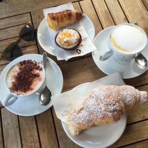 una mesa con dos platos de bollería y una taza de café en B&B La Perla, en Vibo Valentia Marina