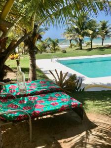 a table with a bottle on it next to a pool at Pé na Areia in Conde