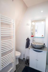 ein Bad mit einem Waschbecken und einem WC in der Unterkunft Warm Studio en duplex proche Paris et Disney in Neuilly-Plaisance