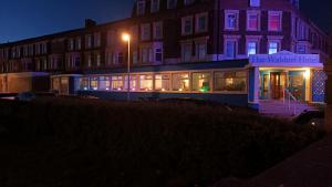 un edificio iluminado por la noche con luces púrpuras y rosas en The Waldorf - Near Pleasure Beach & Sandcastle, en Blackpool