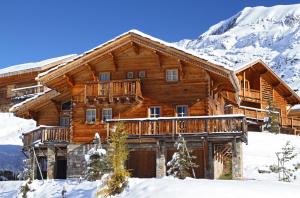 a log cabin in the snow at Odalys Chalet Melusine in L'Alpe-d'Huez