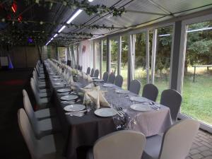 a long long table with white chairs and tablesearcher at Gościniec Borne Sulinowo - Była Baza Wojskowa in Borne Sulinowo