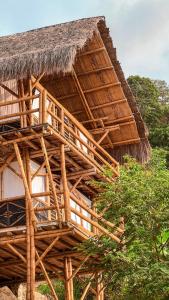 a bamboo building with a thatched roof at Niuwi Hostel in Buritaca