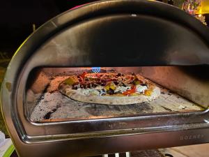 a pizza is being cooked in an oven at Gorge View Bush Retreat : Katherine NT in Katherine