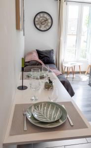 a table with a plate and wine glasses on it at Warm Studio en duplex proche Paris et Disney in Neuilly-Plaisance