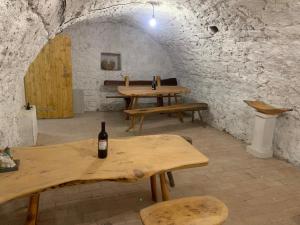 una camera con tavoli in legno e una bottiglia di vino di Loft Pihenő és Wellness Ház a Balatonfüred