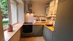 a kitchen with white cabinets and a sink and a window at Your Space in Jurmala in Jūrmala