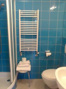 a blue tiled bathroom with a toilet and a sink at Apartment Rainbow Studio in Ljubljana