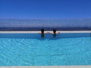 dos personas están sentadas en una piscina en Casa Nine con piscina en Breña Baja