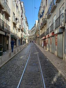 uma rua vazia com linhas de comboio numa cidade em City Inn em Lisboa