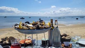 a table with a bowl of seafood and a bottle of champagne at Là Casa 1908 in Le Porge +5 photos