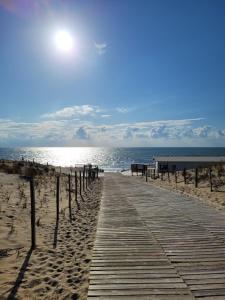 a wooden pathway on a beach with the ocean at Là Casa 1908 in Le Porge