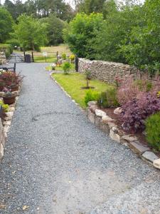 um caminho de jardim com flores e uma parede de pedra em St Mullins Camping em Saint Mullins