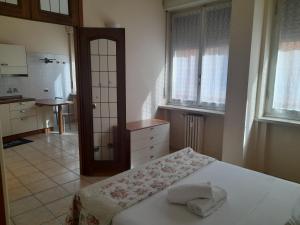 a bedroom with a bed and a kitchen with windows at Giulietta Apartments City Centre Verona in Verona