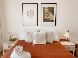 a bedroom with a bed with three pictures on the wall at Byron Butter Factory Apartments in Byron Bay