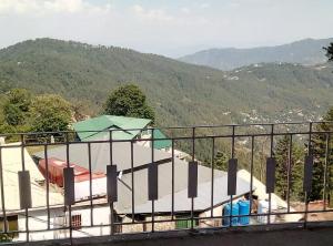 a balcony with a view of a house at Stairway to Heaven in Murree