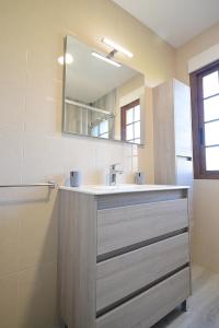 een badkamer met een wastafel en een spiegel bij Casa con vistas al mar en Cambados in Cambados