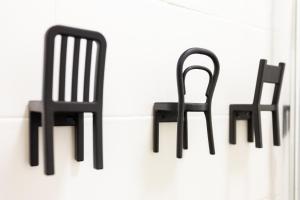 two black chairs sitting next to a wall at Yellow Tiles in City Center in Lisbon