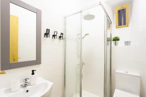 een badkamer met een glazen douche en een wastafel bij Yellow Tiles in City Center in Lissabon
