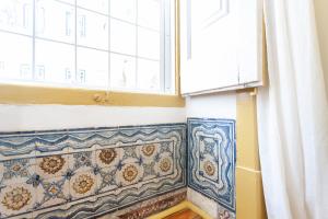 een badkamer met blauwe en witte tegels en een raam bij Yellow Tiles in City Center in Lissabon +47 foto's