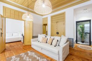 een woonkamer met een witte bank en een slaapkamer bij Yellow Tiles in City Center in Lissabon