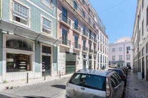 een straat met auto's geparkeerd voor gebouwen bij Yellow Tiles in City Center in Lissabon