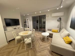 a living room with a couch and a table at Balticus Apartament 2 pokoje, 5-piętro, klimatyzacja, widok na morze, duży balkon, garaż, internet in Międzyzdroje