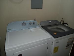 a washing machine with a stove on top of it at Ella's Park View Townhouse Crown Point in Crown Point