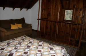 a bedroom with a bed and a couch and a window at La Avutarda in San Carlos de Bariloche