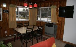 a dining room with a table and chairs and windows at La Avutarda in San Carlos de Bariloche