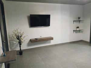 a living room with a tv on a white wall at Consulado Americano a 5 minutos D3 in Ciudad Juárez