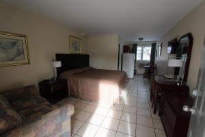 a bedroom with a bed and a desk and a couch at Stardust Motel - Timberlea in Timberlea