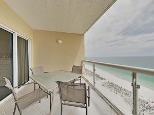 a balcony with a table and chairs and the ocean at Emerald Isle #1606 in Pensacola Beach