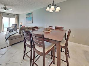 a dining room with a table and chairs and a couch at Emerald Isle #1606 in Pensacola Beach